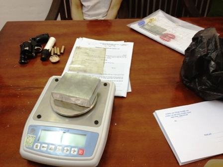 Tang vật vụ án gồm chiếc súng côn quay và một bánh hêrôin (Ảnh: Thái Vân)